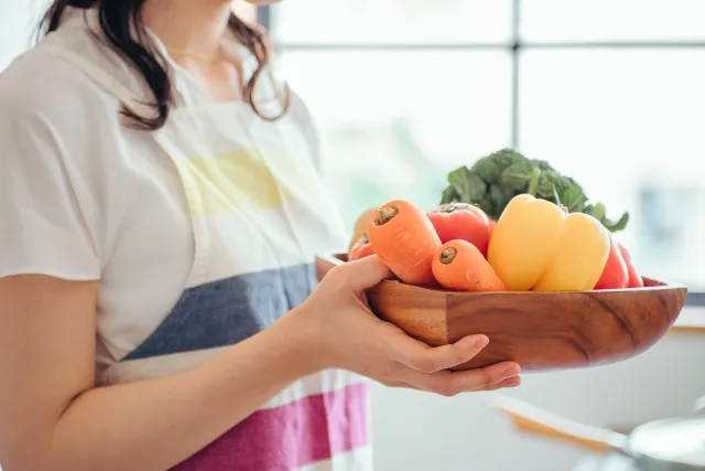 野菜を持つ女性の手元